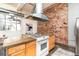 Spacious kitchen with concrete countertops, modern appliances, and exposed brick accent wall at 1777 E 39Th Ave # 209, Denver, CO 80205