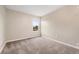 A standard bedroom with neutral walls, carpet, and a window providing natural light at 10001 E Evans Ave # D, Aurora, CO 80247