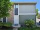 View of home with a stone accent wall and a white front door surrounded by green shrubbery and grass at 10001 E Evans Ave # D, Aurora, CO 80247