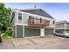 View of townhome with private balcony, two garage doors, and updated gray and green paint at 10001 E Evans Ave # D, Aurora, CO 80247
