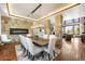 Elegant dining room featuring a stone accent wall with a modern fireplace and a stylish chandelier above a large table at 5650 E Stanford Dr, Cherry Hills Village, CO 80111