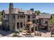 Stunning stone home with an expansive outdoor patio featuring a stone fireplace and water feature at 5650 E Stanford Dr, Cherry Hills Village, CO 80111