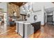 Open-concept kitchen with a large island, stone fireplace, wooden floors and views into the living area at 5650 E Stanford Dr, Cherry Hills Village, CO 80111