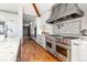 Bright kitchen with stainless steel appliances, a marble countertop, and white cabinetry providing ample storage and counter space at 5650 E Stanford Dr, Cherry Hills Village, CO 80111