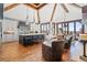 Open concept kitchen with a large island, wooden floors, vaulted ceilings with exposed beams, and abundant natural light at 5650 E Stanford Dr, Cherry Hills Village, CO 80111