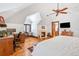Spacious main bedroom featuring a fireplace, sitting area, wood floors and a fan to circulate the air at 5650 E Stanford Dr, Cherry Hills Village, CO 80111