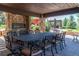 Elegant outdoor dining area with a stone fireplace, large table, and beautiful views of the surrounding landscape at 5650 E Stanford Dr, Cherry Hills Village, CO 80111