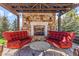 Inviting outdoor seating area with a fireplace, stone backdrop, and stylish furniture for cozy gatherings at 5650 E Stanford Dr, Cherry Hills Village, CO 80111