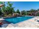 This beautiful pool features a rock waterfall, seating area, and mature landscaping around the backyard at 5650 E Stanford Dr, Cherry Hills Village, CO 80111