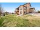 The home's large backyard features a spacious lawn and a wooden deck with stairs at 5998 Berry Ridge Way, Castle Rock, CO 80104