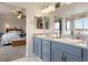 Elegant bathroom featuring dual sinks, modern fixtures, and stylish design, with bedroom view at 5998 Berry Ridge Way, Castle Rock, CO 80104