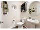 Cozy half bathroom features a pedestal sink and decorative shelving at 5998 Berry Ridge Way, Castle Rock, CO 80104