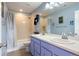 Charming bathroom featuring a double sink vanity with blue cabinets and a shower-tub combo at 5998 Berry Ridge Way, Castle Rock, CO 80104