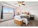 Bright bedroom featuring a large window with scenic views, tray ceilings, and comfortable furniture at 5998 Berry Ridge Way, Castle Rock, CO 80104