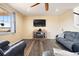 Comfortable living room features dark wood floors, fireplace, large TV and plenty of seating at 5998 Berry Ridge Way, Castle Rock, CO 80104