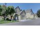 View of a tan two-story home with a two-car garage and a well-manicured lawn on a sunny day at 10359 W Fair Ave # F, Littleton, CO 80127