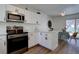 Modern kitchen with white cabinets, stainless steel appliances, and wood-look flooring at 10359 W Fair Ave # F, Littleton, CO 80127