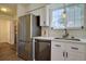 Kitchen featuring stainless steel appliances, white cabinets, and a window overlooking the backyard at 10359 W Fair Ave # F, Littleton, CO 80127