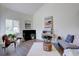 Open living room with a fireplace, large windows, and neutral decor at 10359 W Fair Ave # F, Littleton, CO 80127