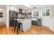 A modern kitchen featuring an island with seating, stainless steel appliances, and a view of the yard at 4655 Ludlow St, Boulder, CO 80305