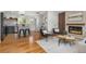 Open-concept living room with hardwood floors, fireplace, and modern kitchen in the background at 4655 Ludlow St, Boulder, CO 80305