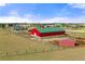 Expansive red barn with a green roof, complemented by surrounding pastures and outbuildings at 2190 Helen Ct, Parker, CO 80138