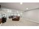 Spacious basement featuring gray carpet, modern lighting, and a comfortable brown leather sectional at 2190 Helen Ct, Parker, CO 80138