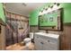 Charming bathroom features a rustic wood-themed shower curtain and wall accents with a white vanity at 2190 Helen Ct, Parker, CO 80138