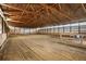 A large indoor horse riding arena with sand and wood beam ceilings at 2190 Helen Ct, Parker, CO 80138