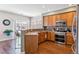Modern kitchen featuring wood cabinets, stainless steel appliances, and a bar area at 23110 York Ave, Parker, CO 80138
