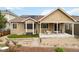 Well-maintained backyard with a covered patio, artificial turf, and a charming bridge feature at 2724 Rising Moon Way, Castle Rock, CO 80109
