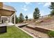 Beautiful backyard featuring a decorative stream bed, patio seating, and well-manicured lawn at 2724 Rising Moon Way, Castle Rock, CO 80109