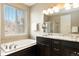 Luxurious bathroom boasts dark cabinets, dual sinks, a soaking tub, and a walk-in shower at 2724 Rising Moon Way, Castle Rock, CO 80109