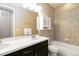 Well-lit bathroom features a double sink vanity, storage cabinet, and shower-over-tub with tile surround at 2724 Rising Moon Way, Castle Rock, CO 80109