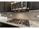 Close-up of a gas stove, granite countertops and decorative tile backsplash at 2724 Rising Moon Way, Castle Rock, CO 80109