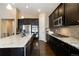 Spacious kitchen featuring an island, dark cabinets, stainless appliances, and granite countertops at 2724 Rising Moon Way, Castle Rock, CO 80109