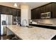 Beautiful kitchen featuring an island, dark cabinets, stainless appliances, and granite countertops at 2724 Rising Moon Way, Castle Rock, CO 80109
