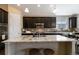 Updated kitchen with island, dark cabinets, granite countertops, and stainless steel appliances at 2724 Rising Moon Way, Castle Rock, CO 80109
