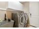 Convenient laundry room featuring front-load washer and dryer, utility sink, and ample cabinet space at 2724 Rising Moon Way, Castle Rock, CO 80109