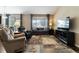 Bright living room with large windows, neutral colors, and comfortable seating at 2724 Rising Moon Way, Castle Rock, CO 80109