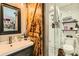Modern bathroom featuring a stylish vanity, mirror, and a tiled walk-in shower with a unique sliding door at 6213 Willow Ln, Boulder, CO 80301