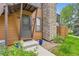 Exterior view of a home entrance with a stone chimney and green yard at 6213 Willow Ln, Boulder, CO 80301