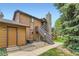 A view of a home's exterior with a stone chimney and stairs leading to an upper unit at 6213 Willow Ln, Boulder, CO 80301