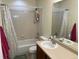 Bright bathroom featuring a tub shower with white tile and a single sink vanity at 10636 Racine Cir, Commerce City, CO 80022