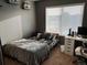 Neutral bedroom with a platform bed, gray walls, a window, and a desk area for studying at 10636 Racine Cir, Commerce City, CO 80022