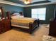 Main bedroom with a dark teal accent wall and a wooden sleigh bed at 10636 Racine Cir, Commerce City, CO 80022