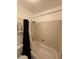 Bathroom tub and shower featuring neutral tile walls and hardware at 7020 W Portland Ave, Littleton, CO 80128