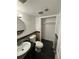 Bathroom featuring black tile, dark vanity, toilet, and closet at 7020 W Portland Ave, Littleton, CO 80128
