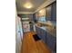 Galley kitchen featuring granite countertops and white appliances at 7020 W Portland Ave, Littleton, CO 80128