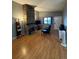 Open concept living room with wood flooring and a floor-to-ceiling stone fireplace at 7020 W Portland Ave, Littleton, CO 80128